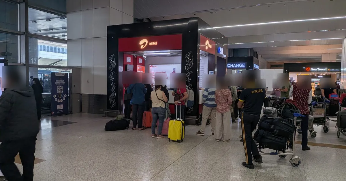 Queue at the Airtel SIM counter in the Delhi T3 international arrivals hall, 17 October 2026 (faces blurred)