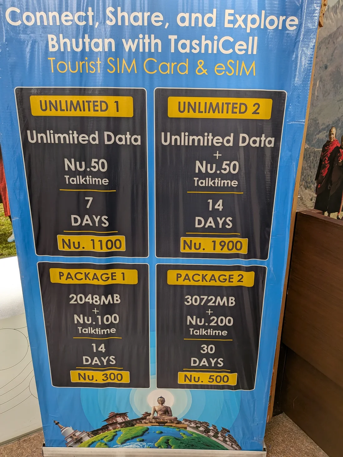 Panneau de prix TashiCell Tourist SIM Card & eSIM à l'aéroport de Paro, photographié en octobre 2026, montrant les forfaits Unlimited 1, Unlimited 2, Package 1 et Package 2